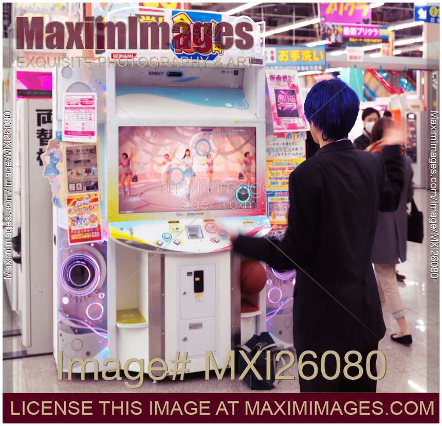 Girl playing dance station slot machine at arcade