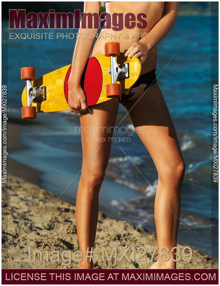 Girl with skateboard on the beach