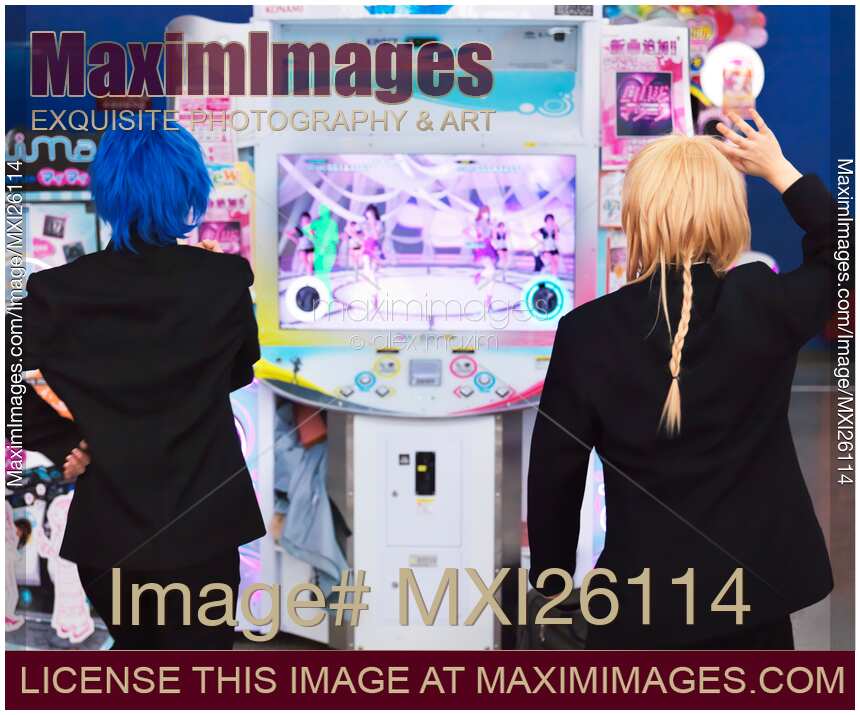 Girls playing dance station slot machine at arcade