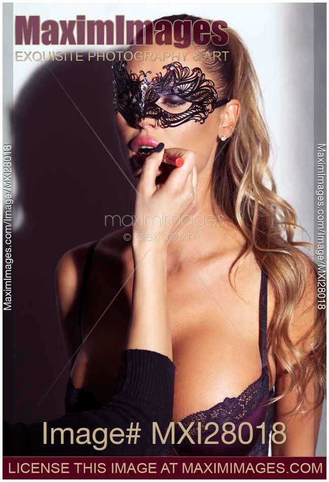 Glamorous sexy woman in mask having her makeup applied