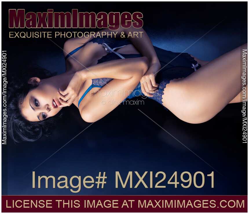 Glamorous woman in blue lingerie lying on the floor
