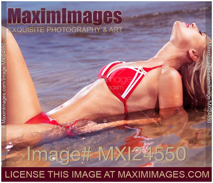 Glamorous young woman in bikini lying in water