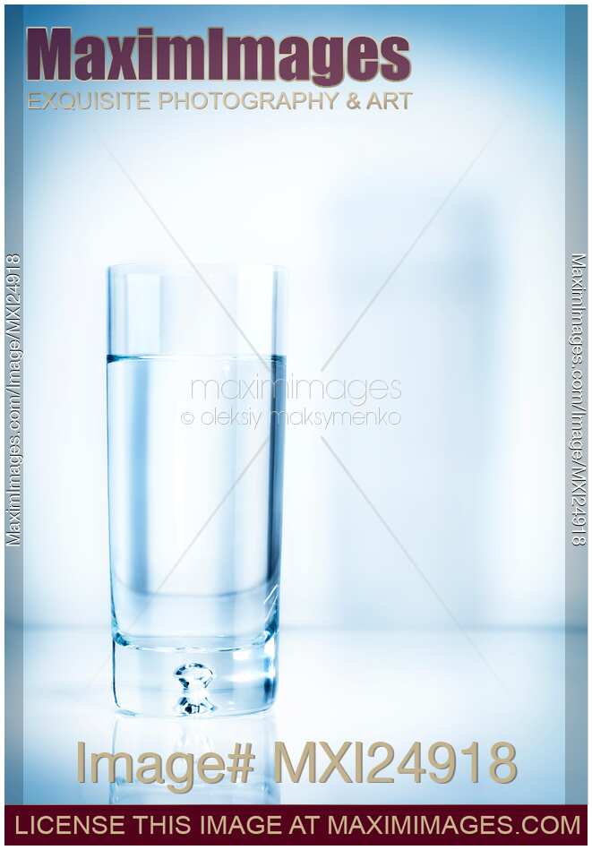 Glass of water on light blue background