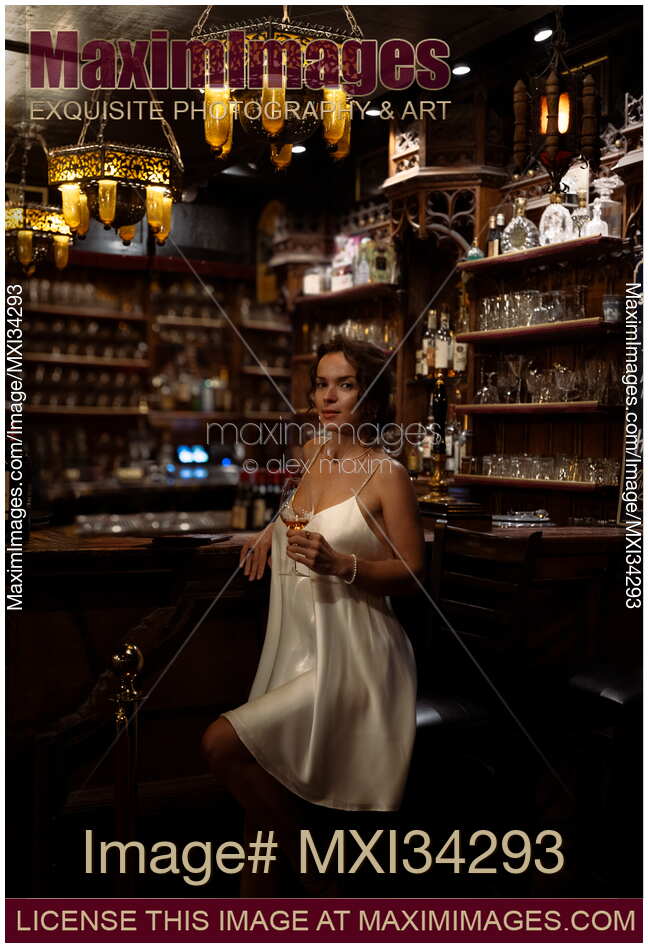 Gorgeous glamorous woman drinking a glass of wine at a bar counter in a pub