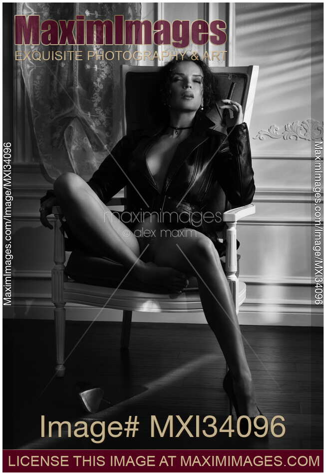 Gorgeous seductive woman in leather jacket sitting half naked in vintage chair smoking a cigar. Black and white. noir.