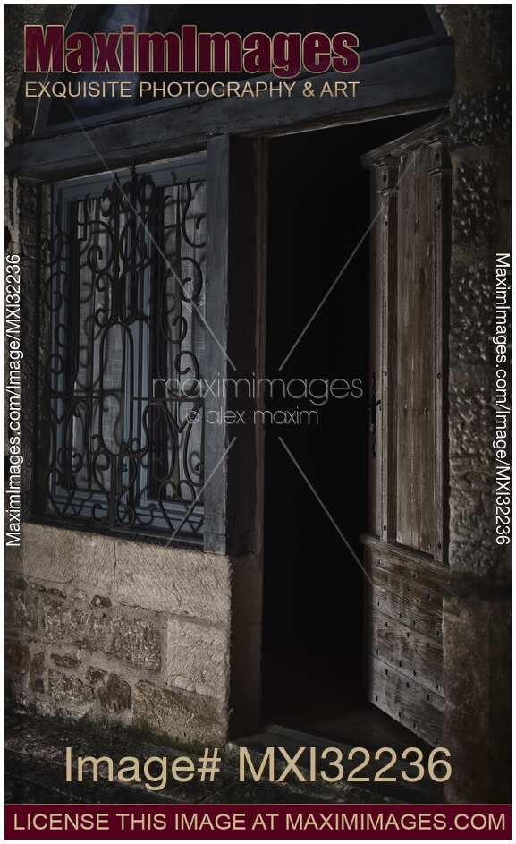 Half open entrance door showing dark house interior from the street at night