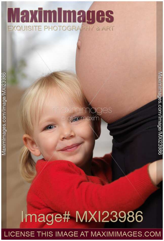 Happy Daughter Hugging Her Pregnant Mother Across Belly