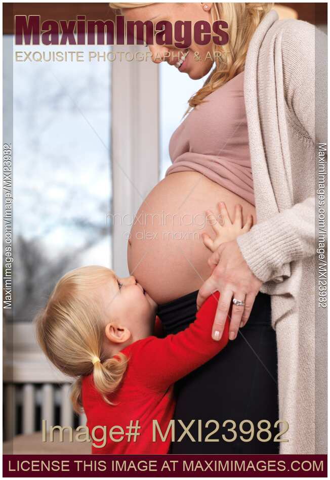 Happy Little Daughter Kissing Her Pregnant Mother's Belly