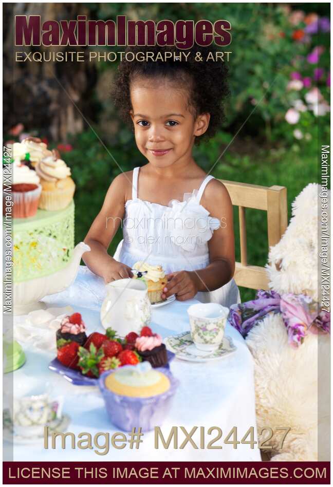 Happy young girl eating a cupcake at a party