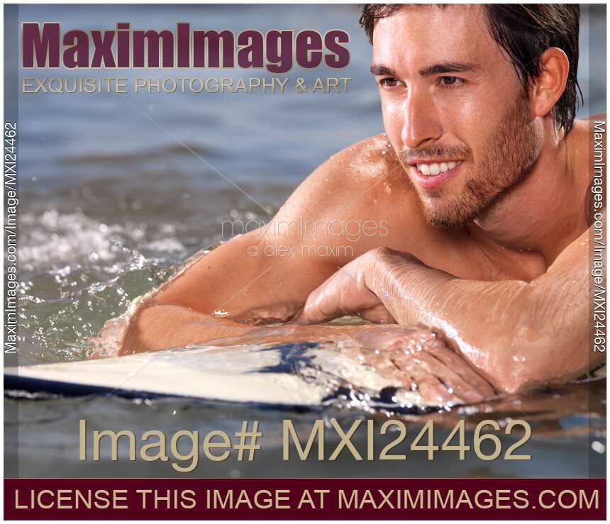 Happy young man with surfboard in water