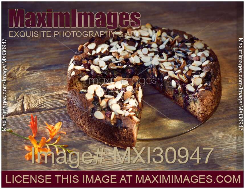 Healthy home-made Banana bread with berries and almonds on a table artistic food still life