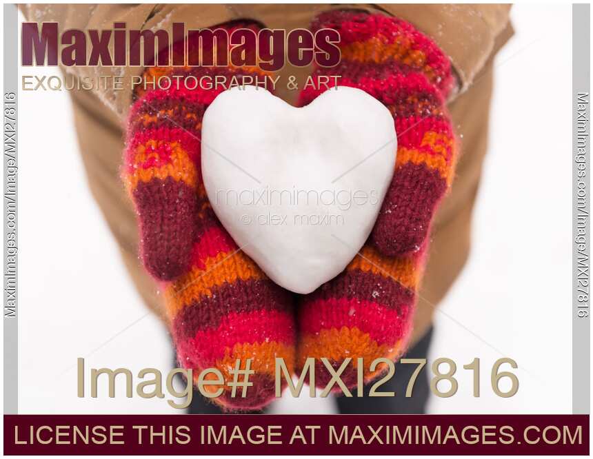 Heart made of snow in woman hands