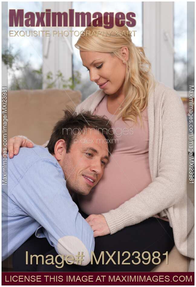 Husband listening to baby moving inside his wife's belly