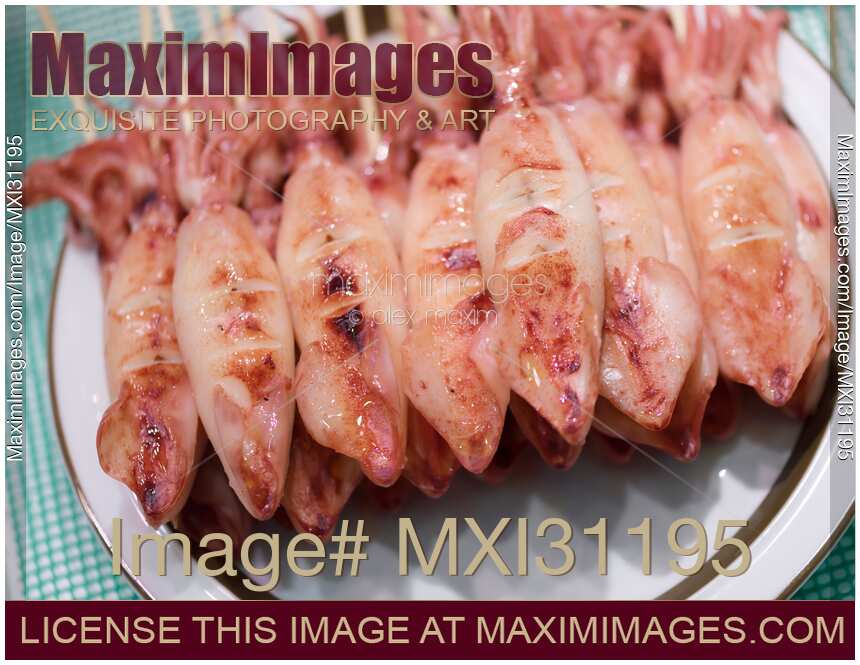 Ikayaki grilled squid skewers Japanese street food at a market stall