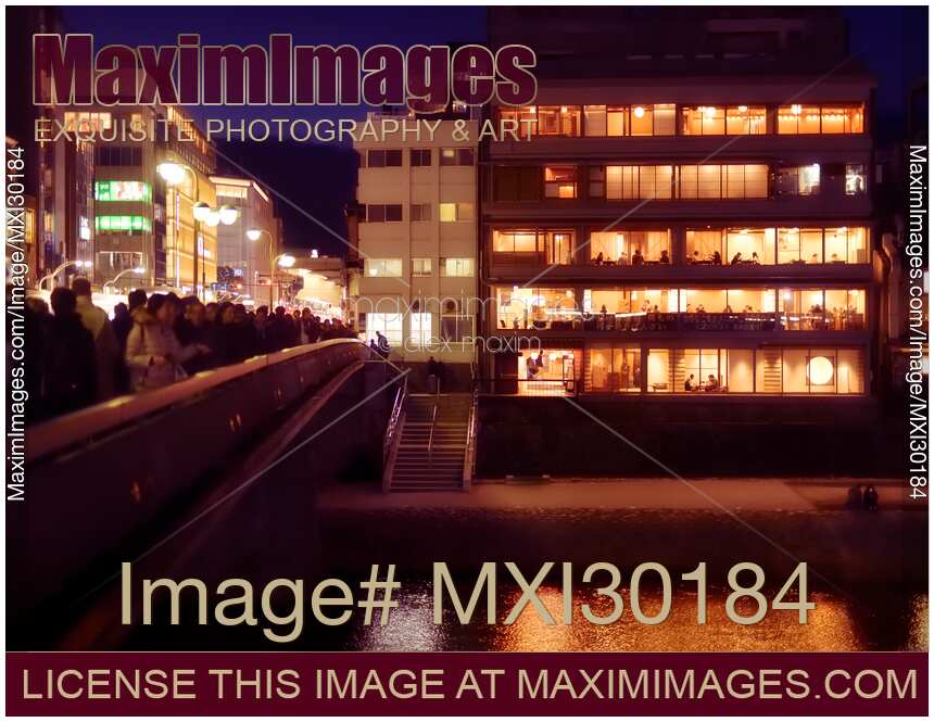 Izumoya Japanese restaurant in Kyoto with windows lit up at night and people dining inside