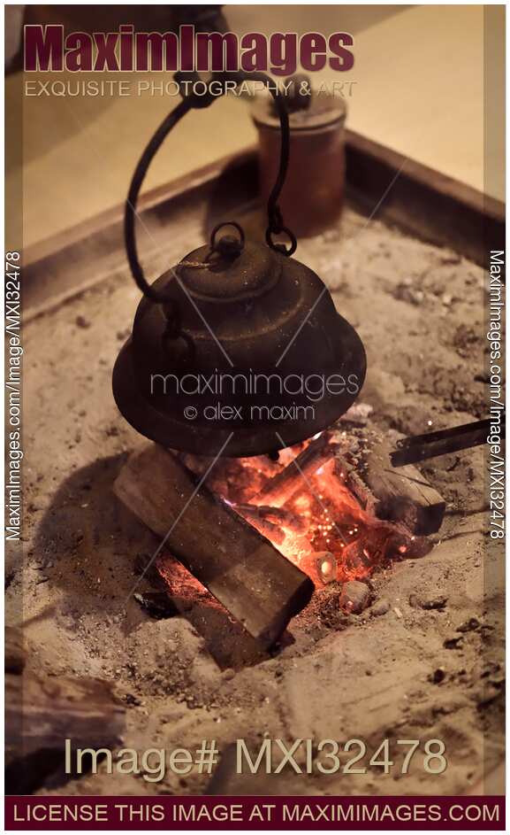 Japanese cast iron kettle Kama on burning firewood in floor hearth