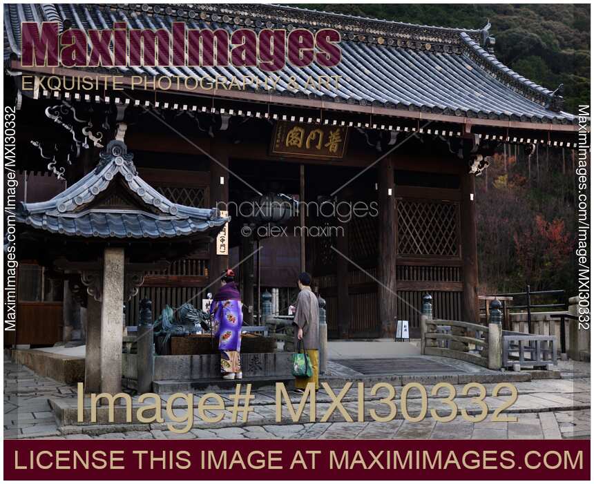 Japanese couple washing hands at chozubachi cleansing basin at Todoroki-mon gate of Kiyomizu-dera temple in Kyoto