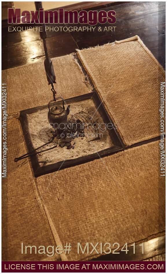 Japanese tea room with a kettle hanging above in a sunken hearth and straw mats around