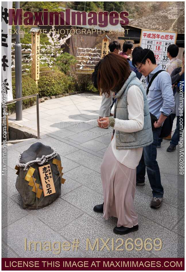 Japanese woman at Jishu Jinja shrine walking towards love rock at Kiyomizu-dera in Kyoto