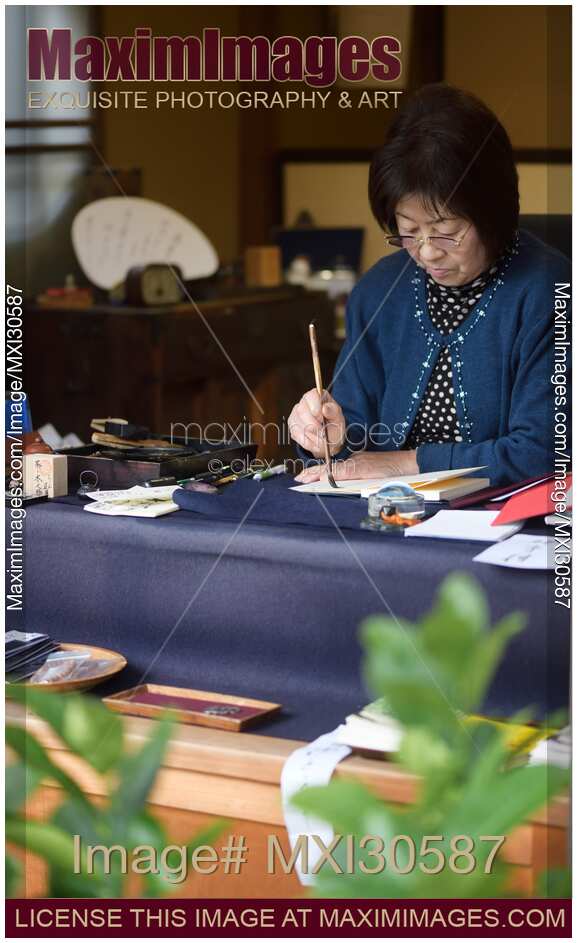 Japanese woman calligrapher writing at a desk