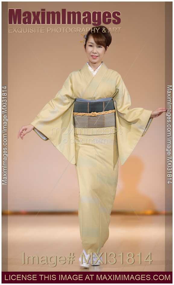 Japanese woman in a beige kimono at a fashion show