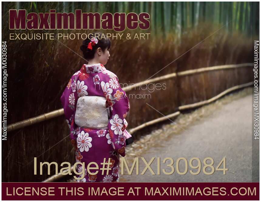 Japanese woman in a kimino walking through Arashiyama bamboo forest in Kyoto
