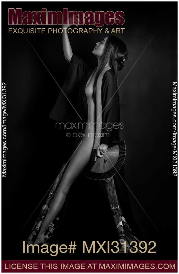 Japanese woman in black kimono revealing her naked body standing in a graceful pose Black and white