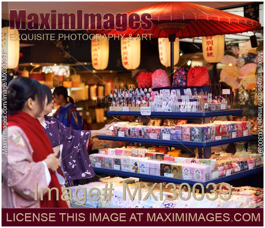 Japanese women in kimonos looking at souvenir store display in Kyoto Japan