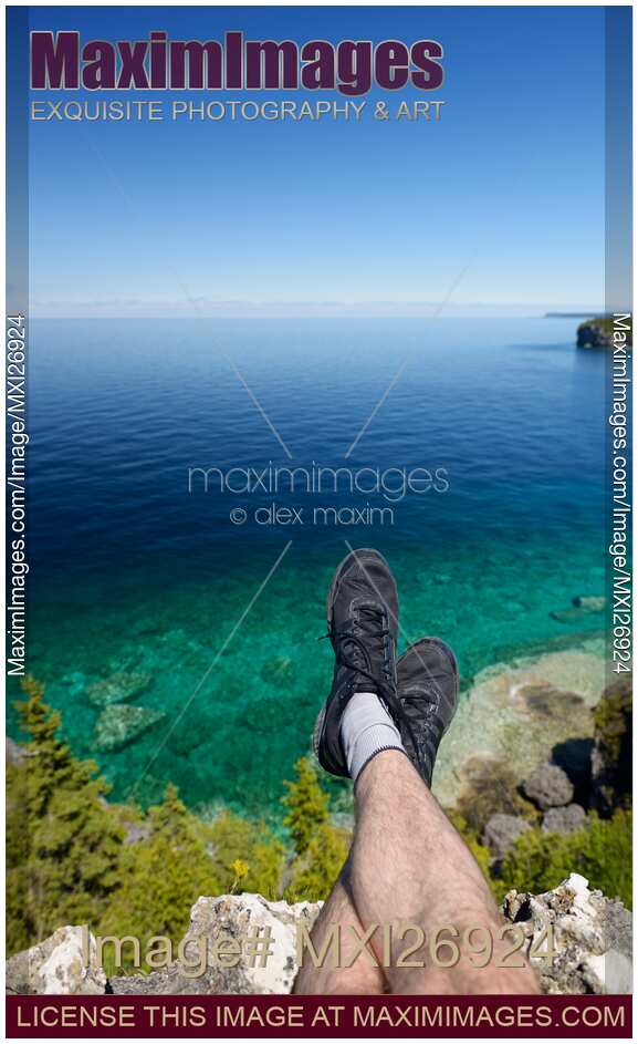 Legs of a person sitting on a cliff of Georgian Bay Bruce Peninsula in Canada