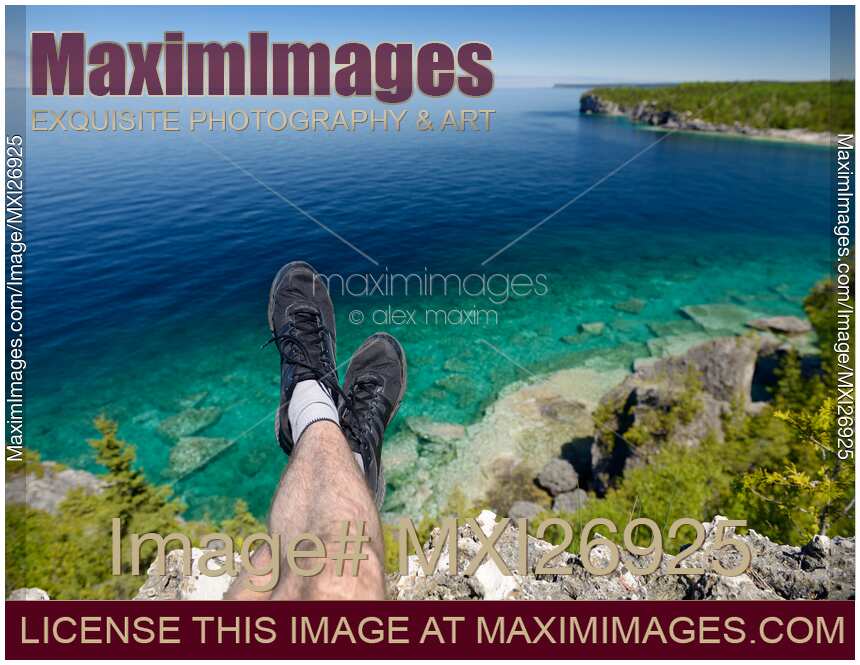 Legs of a person sitting on a cliff of Georgian Bay in Canada
