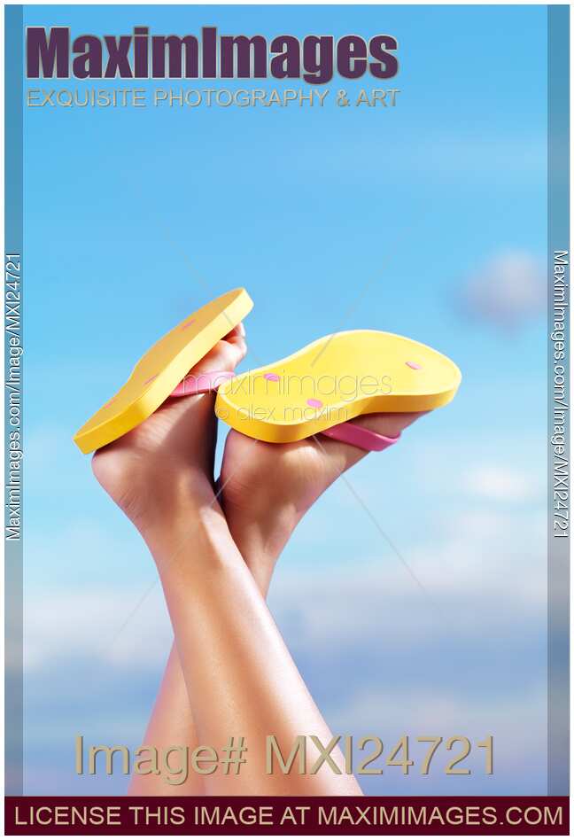 Legs of woman in yellow flip flops