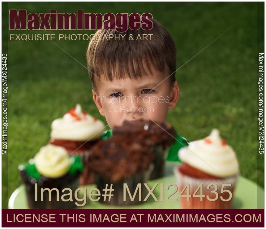 Little boy wants to eat all the cupcakes