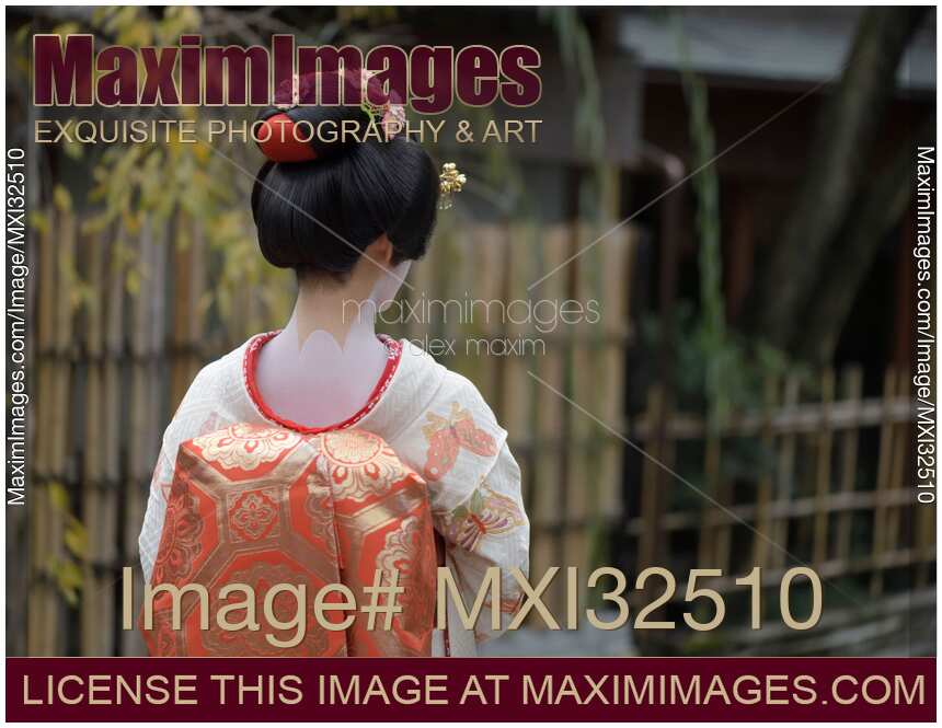 Maiko in white kimono with red collar showing skin makeup on the back of her neck in a traditional wig Kyoto Japan