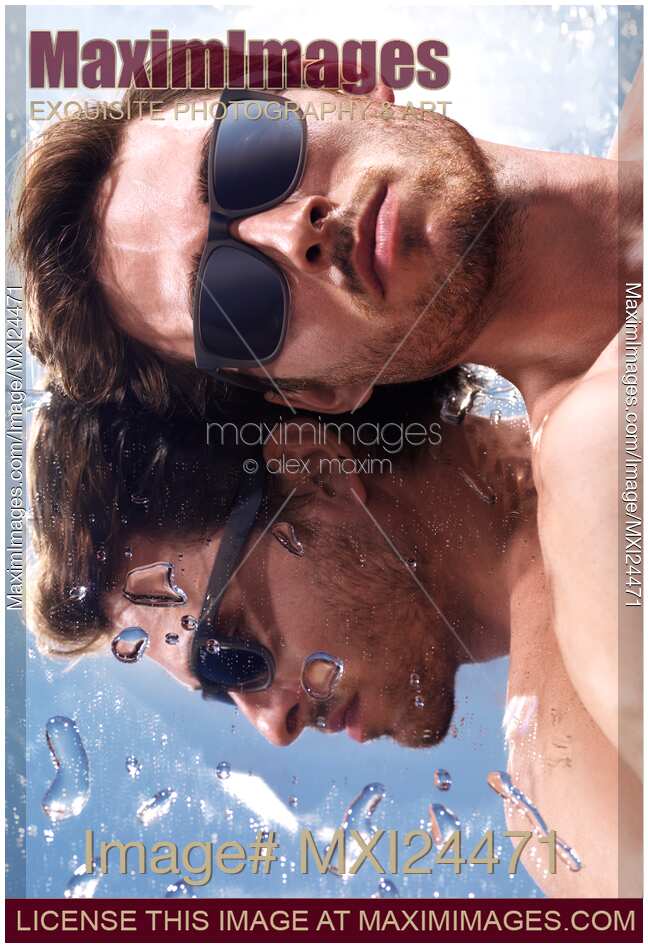 Man in sunglasses lying in the sun on a mirror