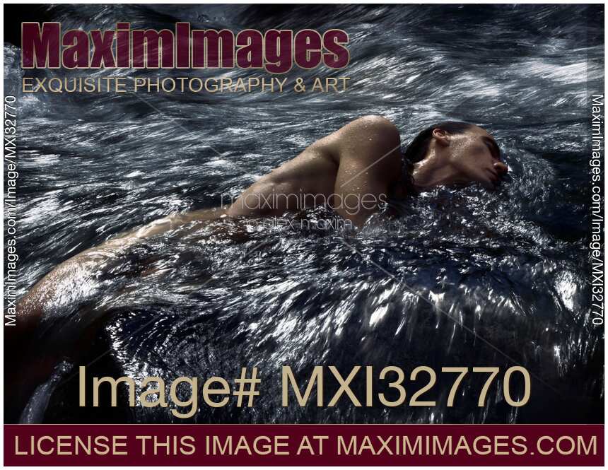 Man lying half submerged in turbulent water of a river stream in dramatic tranquil nature scenery
