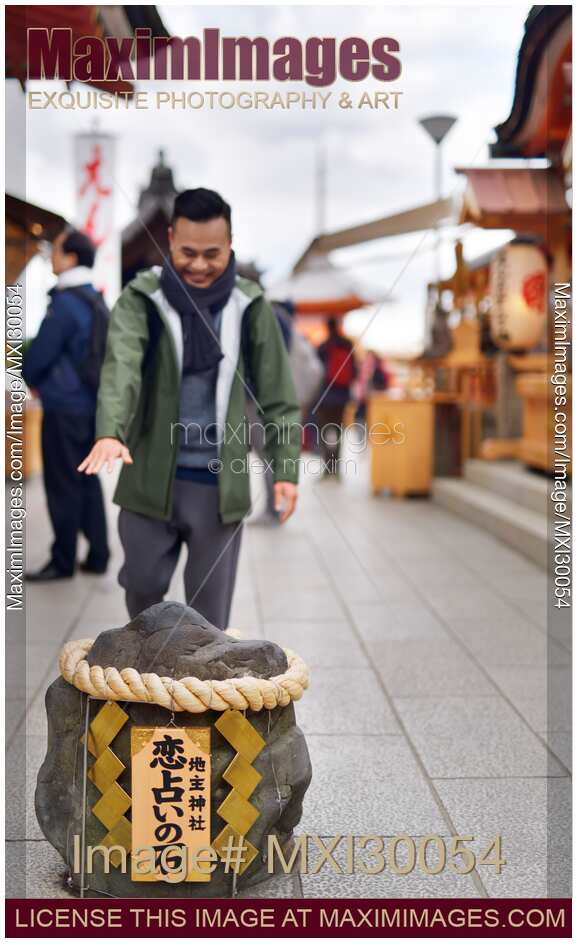 Man walking towards love stone at Jishu Jinja matchmaking shrine at Kiyomizu-dera temple Kyoto