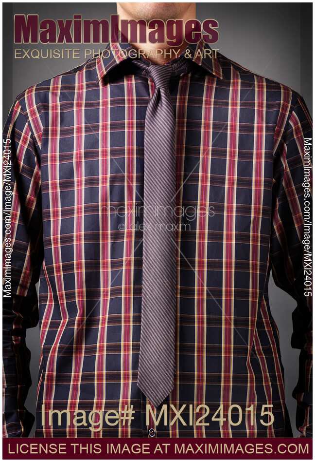 Man wearing a dark tartan shirt with a skinny necktie