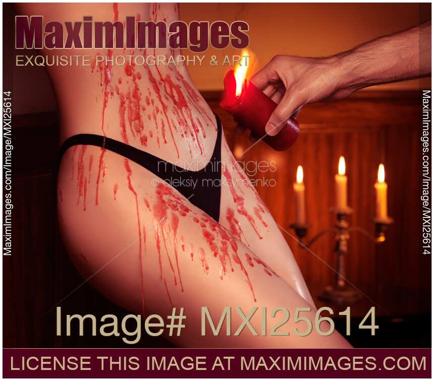 Melted red wax dripping on sexy woman body