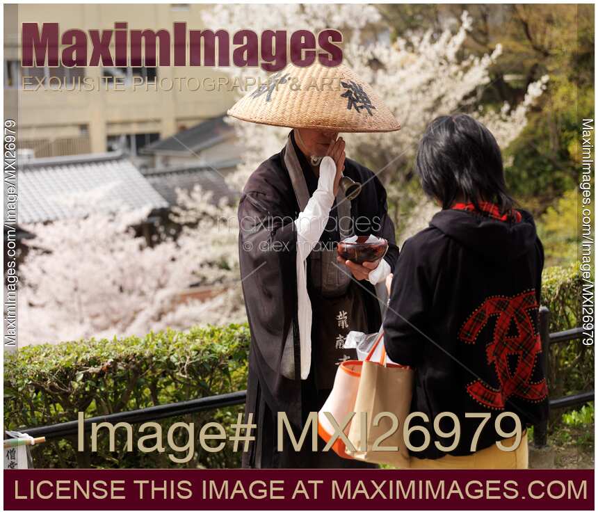 Mendicant Buddhist monk accepting donations