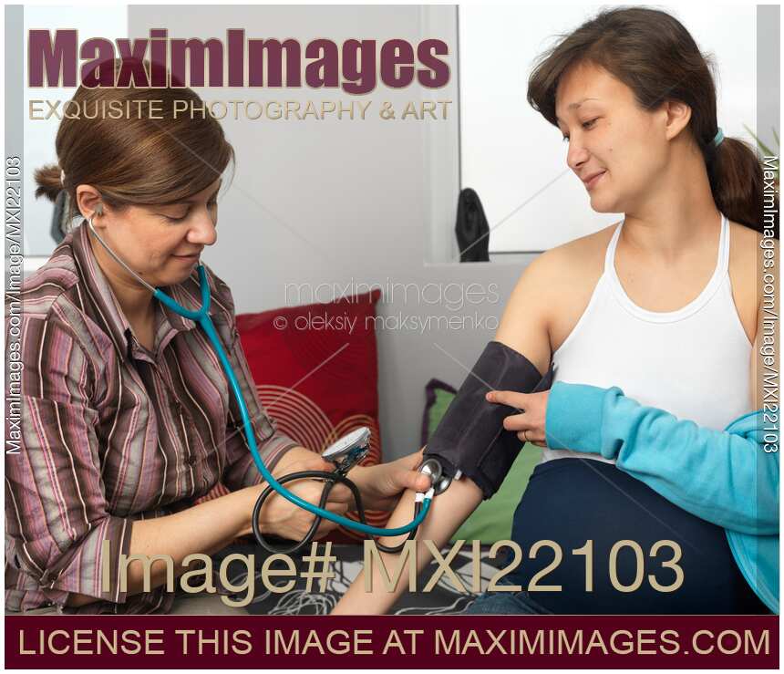 Midwife Measuring Pregnant Woman's Blood Pressure