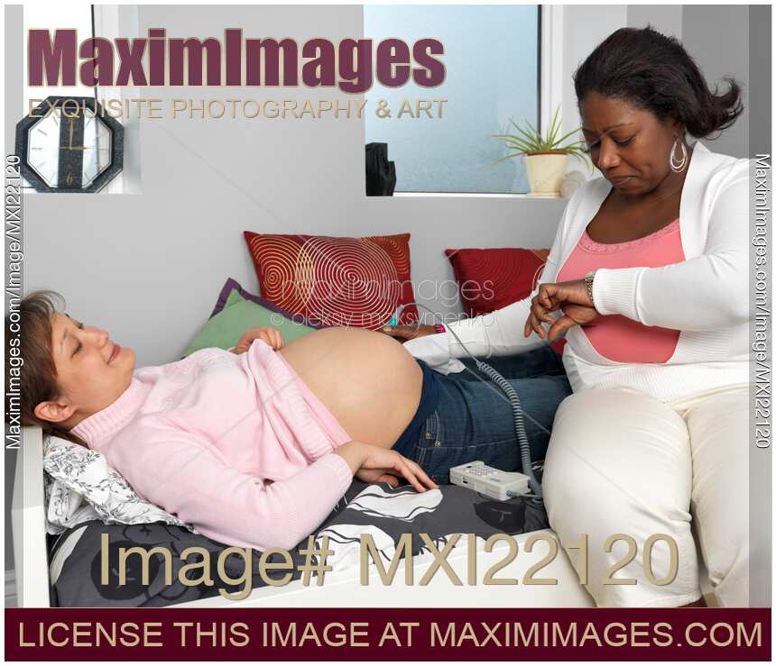 Midwife Monitoring a Pregnant Woman's Baby Heartbeat