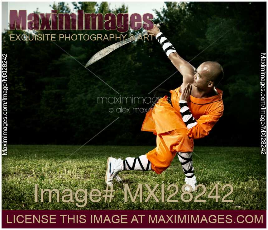 Monk practicing Shaolin broad sword outdoors