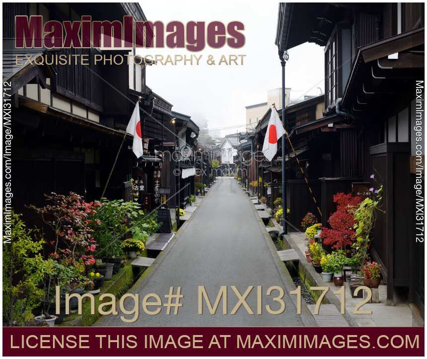 Morning scenery of Kamisannomachi old town street of Hida-Takayama with Japanese flags on Culture day
