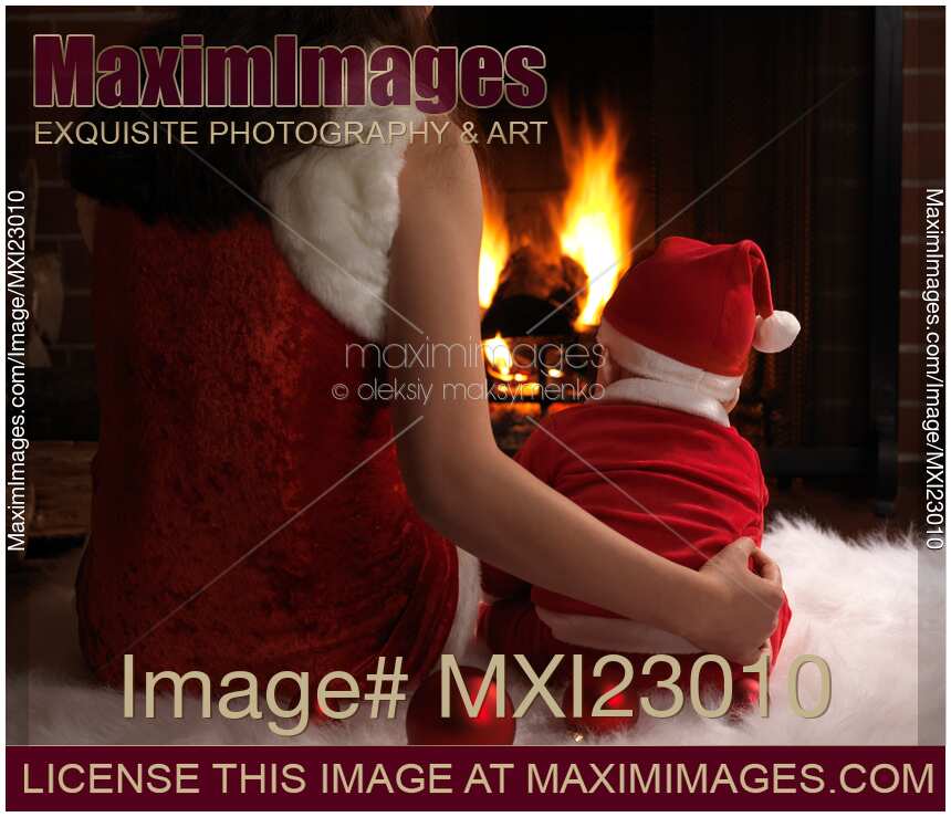 Mother and a Baby Sitting at a Fireplace on Christmas Eve
