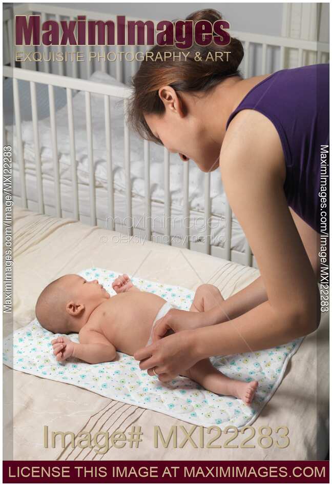 Mother Changing Diaper of a Baby