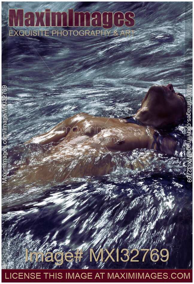 Muscular man bare torso in rushing water of a river Dynamic dramatic fine art photograph