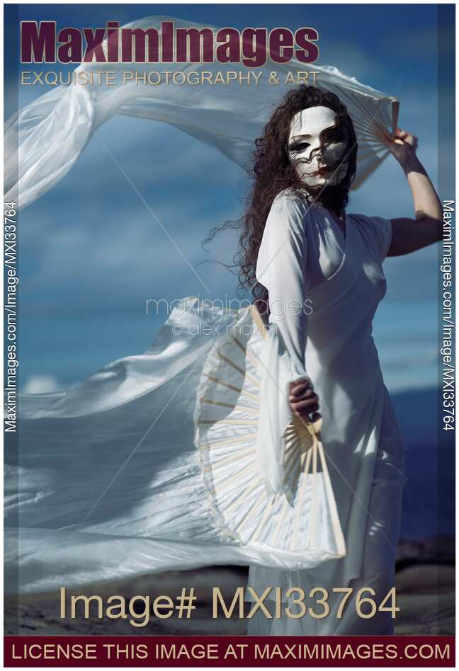Mysterious asian woman in white face mask and dress dancing gracefully with white silk hand fans