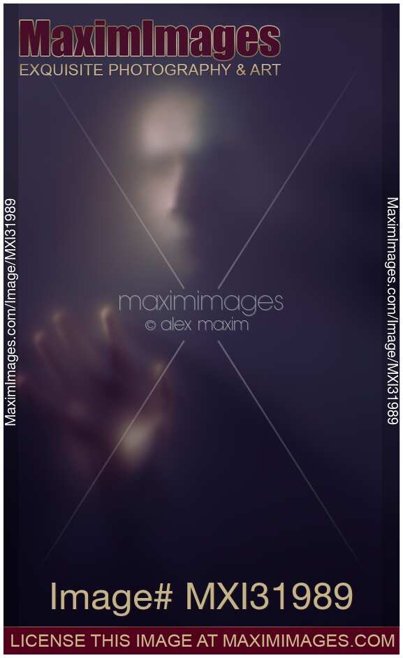 Mysterious portrait of a creepy man ghostly blurred face and hand reaching from darkness through a haze of fog