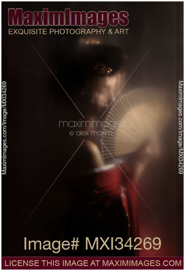Mysterious portrait of beautiful Japanese geisha or courtesan Oiran with hand fan behind hazy screen
