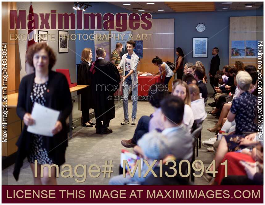 New Canadian citizens receiving their Citizenship certificates at a Citizenship ceremony